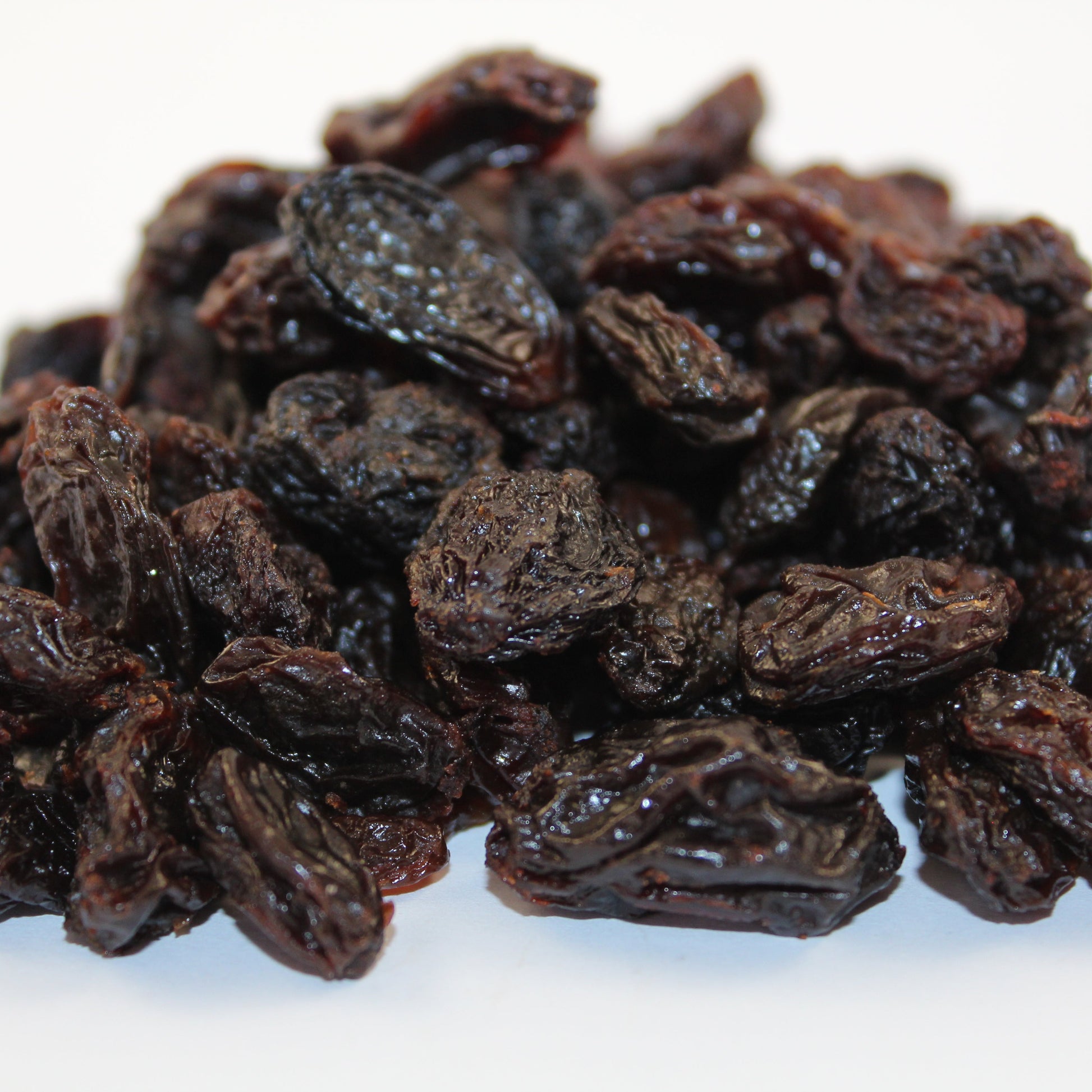 Close-up of dried raisins on a white background